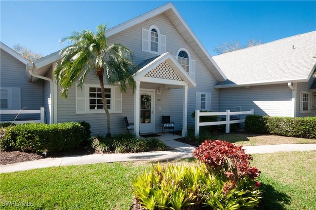 view of front of house with a front yard and fence