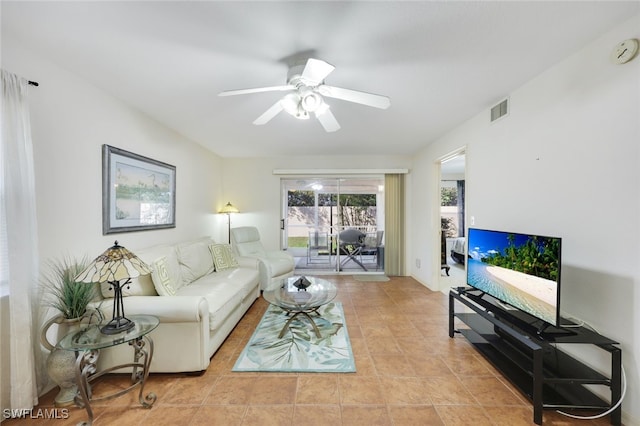 living area featuring tile patterned flooring, visible vents, and a ceiling fan