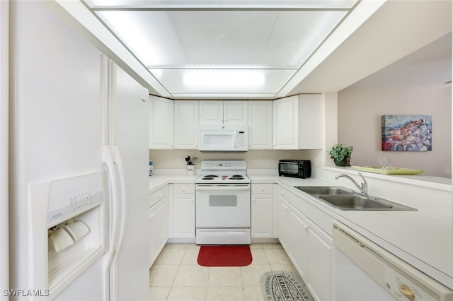 kitchen with white appliances, white cabinets, a sink, and light tile patterned flooring