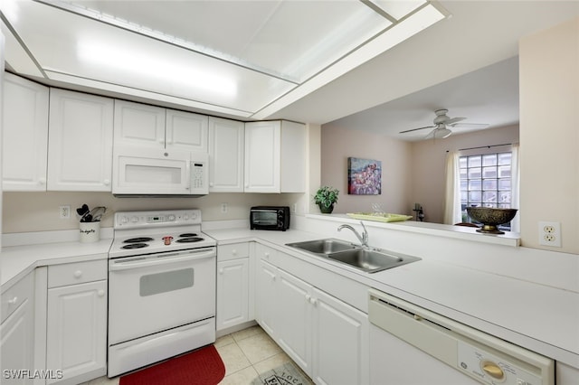 kitchen with white appliances, white cabinetry, a sink, and light tile patterned flooring