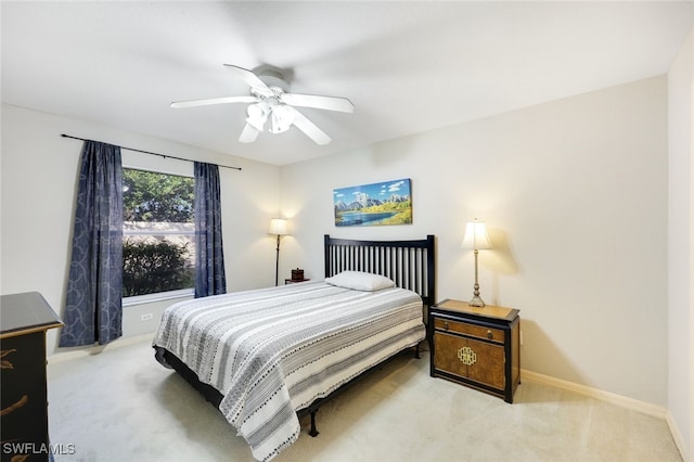 bedroom with light carpet, ceiling fan, and baseboards