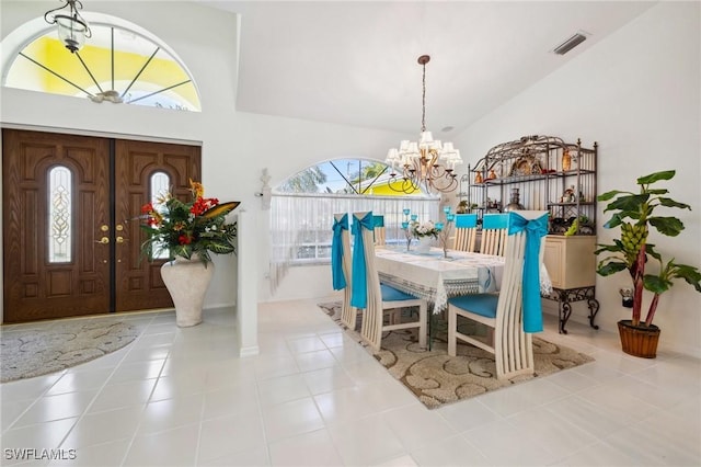 foyer featuring high vaulted ceiling, visible vents, a notable chandelier, and light tile patterned floors