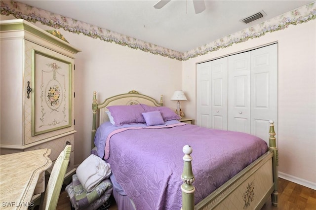 bedroom featuring visible vents, baseboards, dark wood-style floors, ceiling fan, and a closet