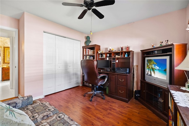 office with dark wood-style floors, baseboards, and a ceiling fan