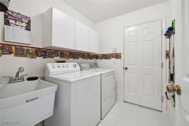 laundry room with independent washer and dryer, cabinet space, a sink, and light tile patterned floors