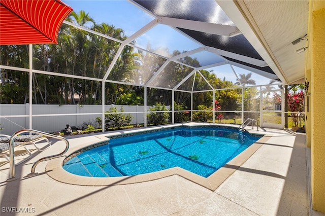 view of pool featuring glass enclosure, a fenced backyard, a fenced in pool, and a patio