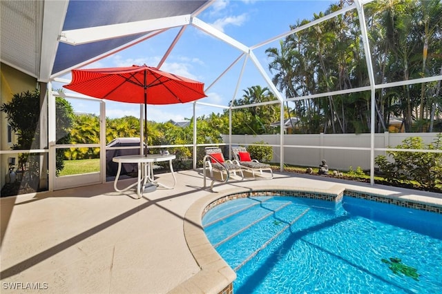 view of swimming pool featuring glass enclosure, a patio area, fence, and a fenced in pool