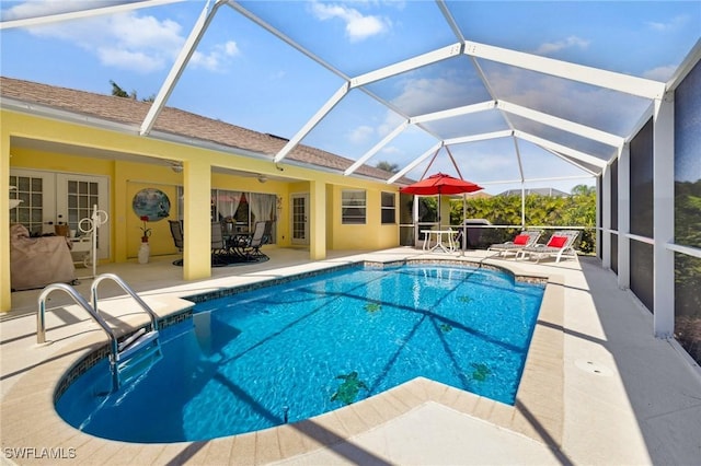 pool with glass enclosure, ceiling fan, and a patio