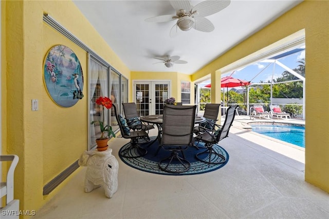 view of patio featuring glass enclosure, ceiling fan, and an outdoor pool