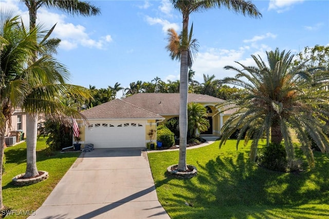 view of front facade featuring a garage, driveway, a front yard, central AC, and stucco siding