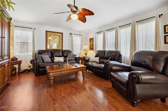 living area with ceiling fan and dark wood-type flooring