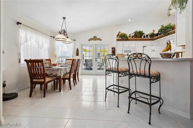 dining area with vaulted ceiling, french doors, and light tile patterned floors