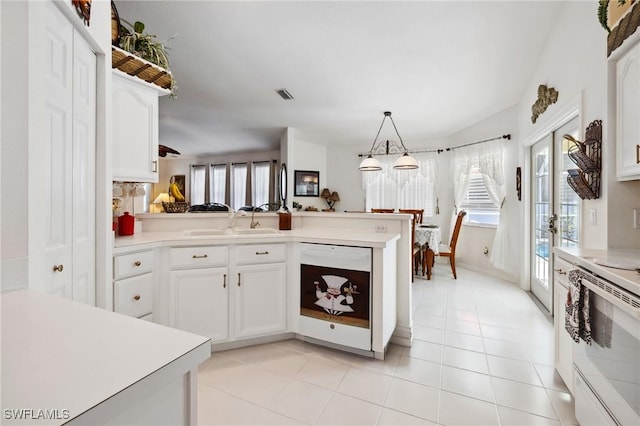 kitchen featuring white appliances, a peninsula, light countertops, white cabinetry, and pendant lighting