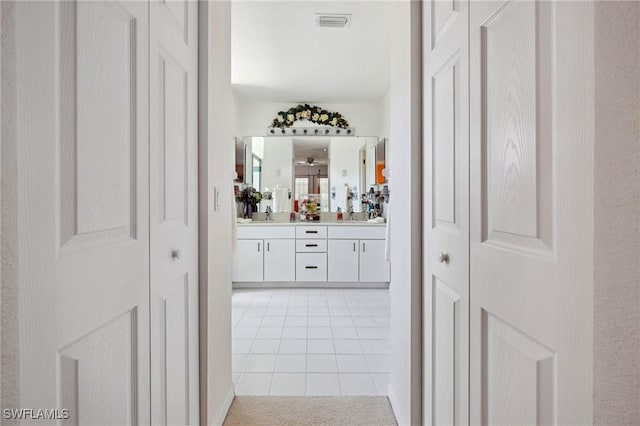 full bathroom featuring double vanity, a closet, visible vents, tile patterned floors, and a sink