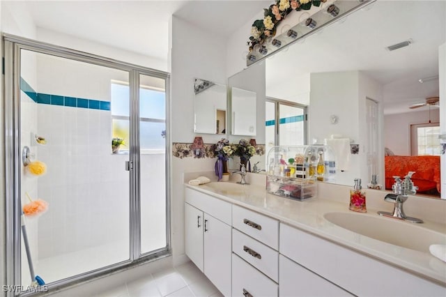 full bathroom featuring double vanity, tile patterned floors, a sink, and a shower stall