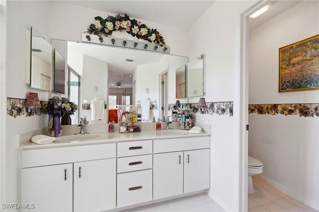 full bath with a sink, toilet, and double vanity