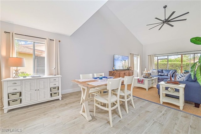 dining space with high vaulted ceiling, light wood-type flooring, and plenty of natural light