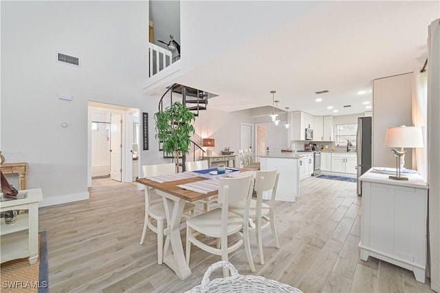 dining room with baseboards, light wood-type flooring, visible vents, and recessed lighting