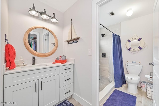 bathroom featuring toilet, vanity, a shower stall, and visible vents