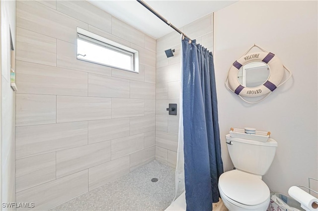 bathroom featuring tiled shower and toilet