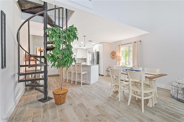 dining room featuring recessed lighting, baseboards, light wood finished floors, and stairs