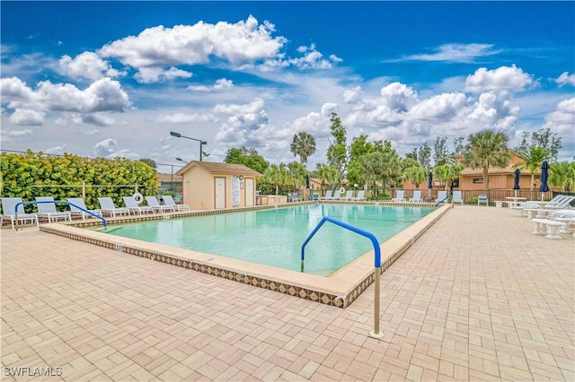 pool with a patio area and fence