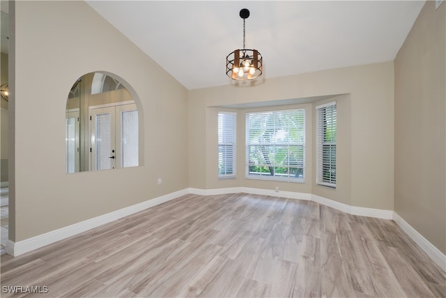 unfurnished room featuring light wood-type flooring, vaulted ceiling, and a chandelier