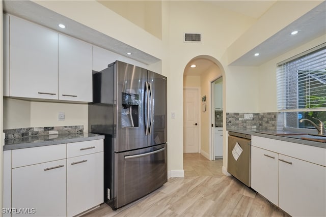 kitchen featuring white cabinets, appliances with stainless steel finishes, sink, and tasteful backsplash