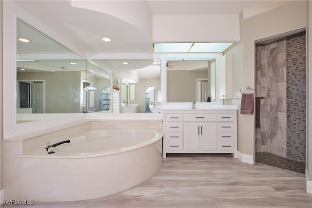 bathroom with vanity and shower with separate bathtub