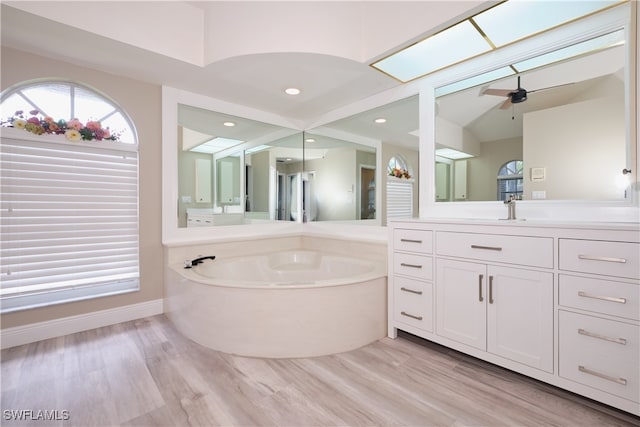 bathroom featuring ceiling fan, vanity, a bathtub, and wood-type flooring