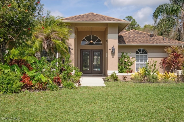 entrance to property with a yard and french doors