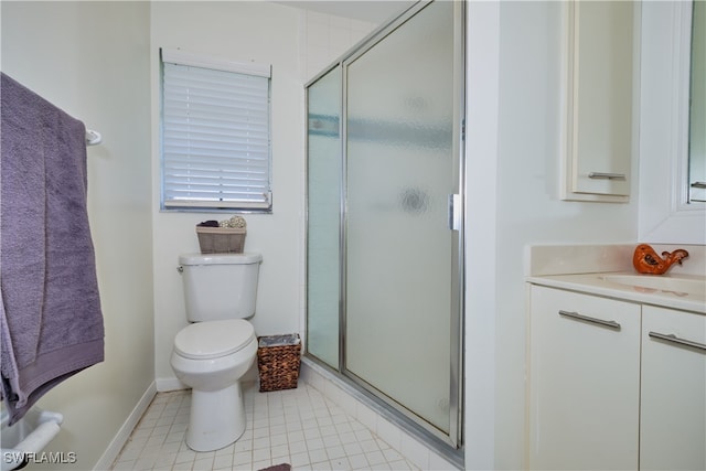 bathroom with tile patterned floors, vanity, toilet, and a shower with door