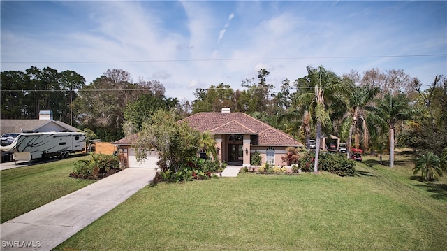 mediterranean / spanish home featuring a front yard and a garage