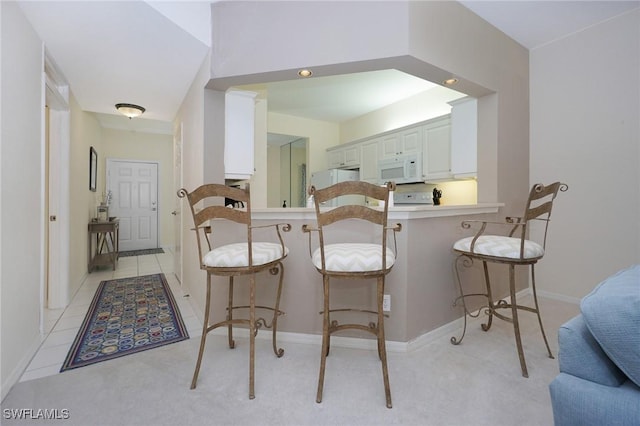 kitchen featuring white cabinetry, kitchen peninsula, and a kitchen breakfast bar