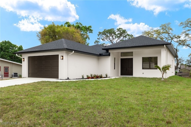 view of front of home featuring a garage, a front lawn, concrete driveway, and roof with shingles