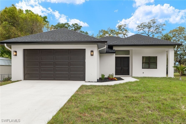 view of front of house with an attached garage, concrete driveway, a front lawn, and a shingled roof