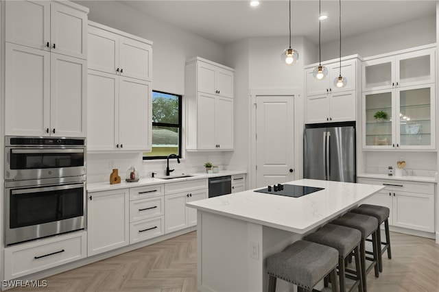 kitchen with glass insert cabinets, a center island, white cabinetry, and black appliances