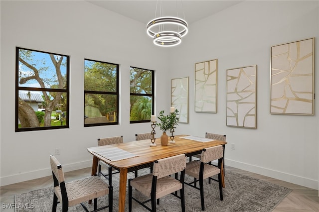 dining space with a notable chandelier and baseboards