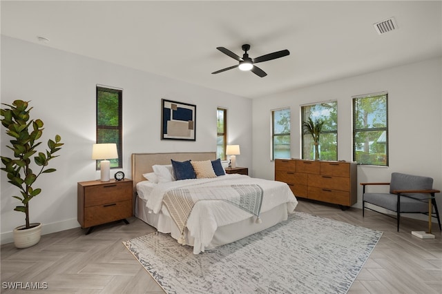 bedroom with visible vents, ceiling fan, baseboards, and multiple windows