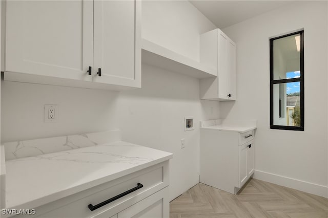 laundry room featuring hookup for a washing machine, cabinet space, and baseboards