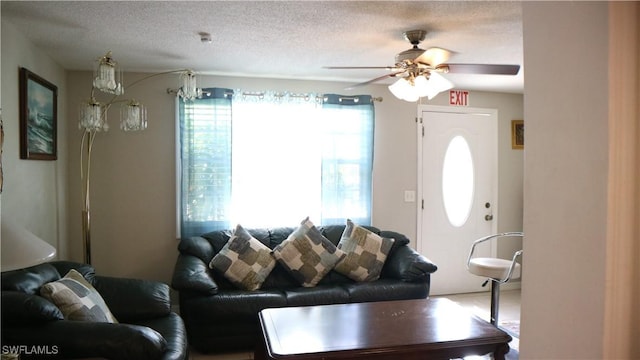 living room featuring ceiling fan and a textured ceiling