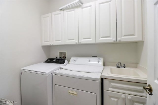 washroom with cabinets, sink, and washing machine and dryer