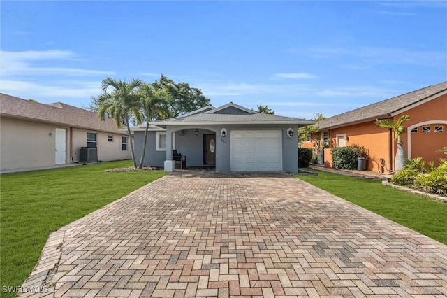 ranch-style home with central air condition unit, a garage, decorative driveway, stucco siding, and a front yard