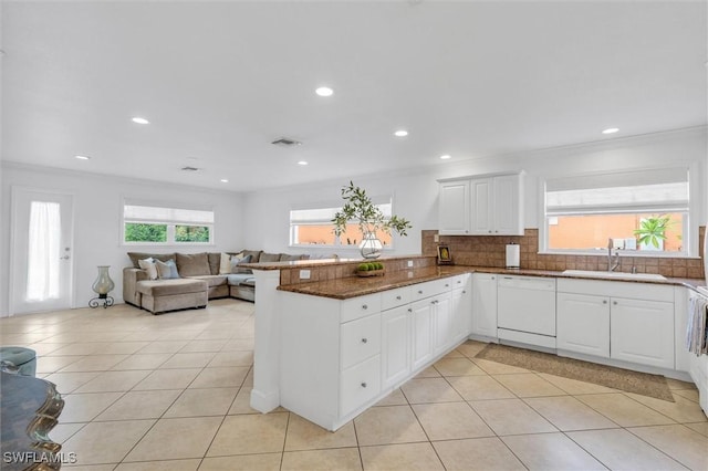 kitchen featuring white cabinetry, dishwasher, a peninsula, and a sink