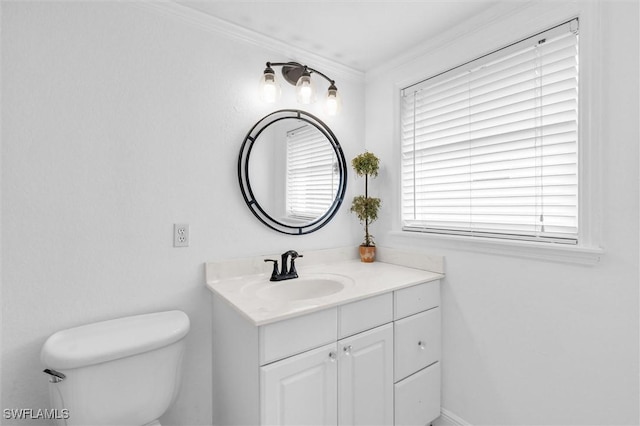 bathroom with crown molding, vanity, and toilet