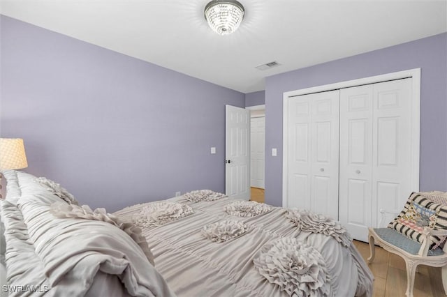 bedroom featuring a closet, visible vents, and light wood-style flooring