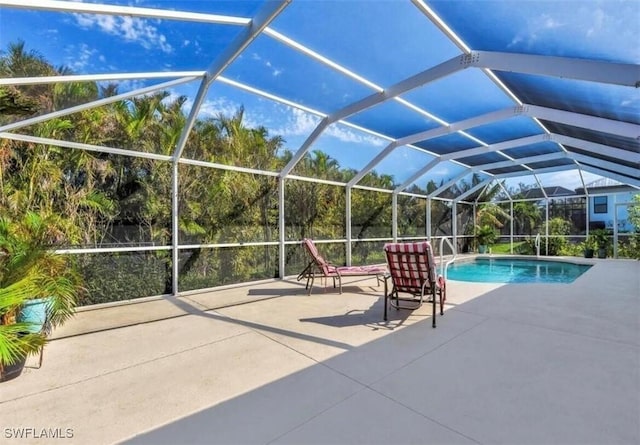 view of pool with a patio area and glass enclosure