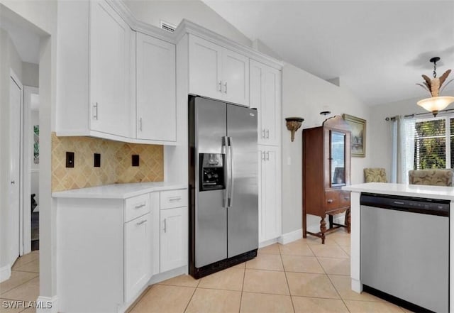 kitchen with tasteful backsplash, light tile patterned floors, white cabinets, and appliances with stainless steel finishes