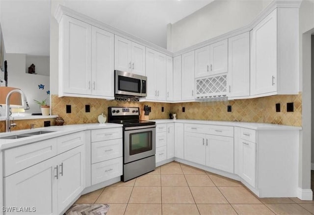 kitchen featuring sink, light tile patterned flooring, white cabinets, and appliances with stainless steel finishes