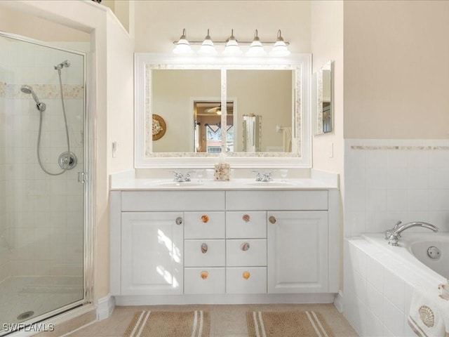 full bathroom with double vanity, a stall shower, a sink, and a bath